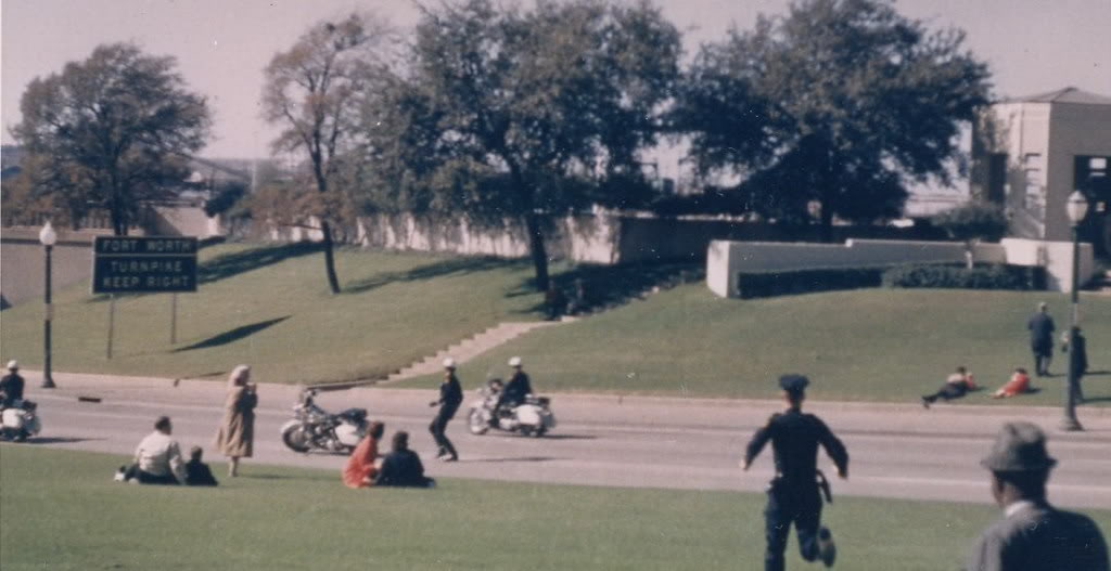 Seconds later, photos show Jean Hill’s red coat flaring as she runs up the steps of the grassy knoll][Bond photo...