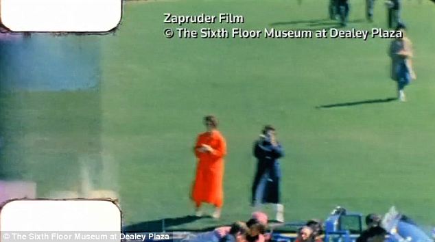 Up close - Mary Ann Moorman is seen in the Zapruder film, as she is in the blue raincoat taking a picture of the President and First Lady in the foreground just as he was shot...